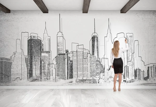 Mulher loira desenhando paisagem urbana na parede de concreto — Fotografia de Stock