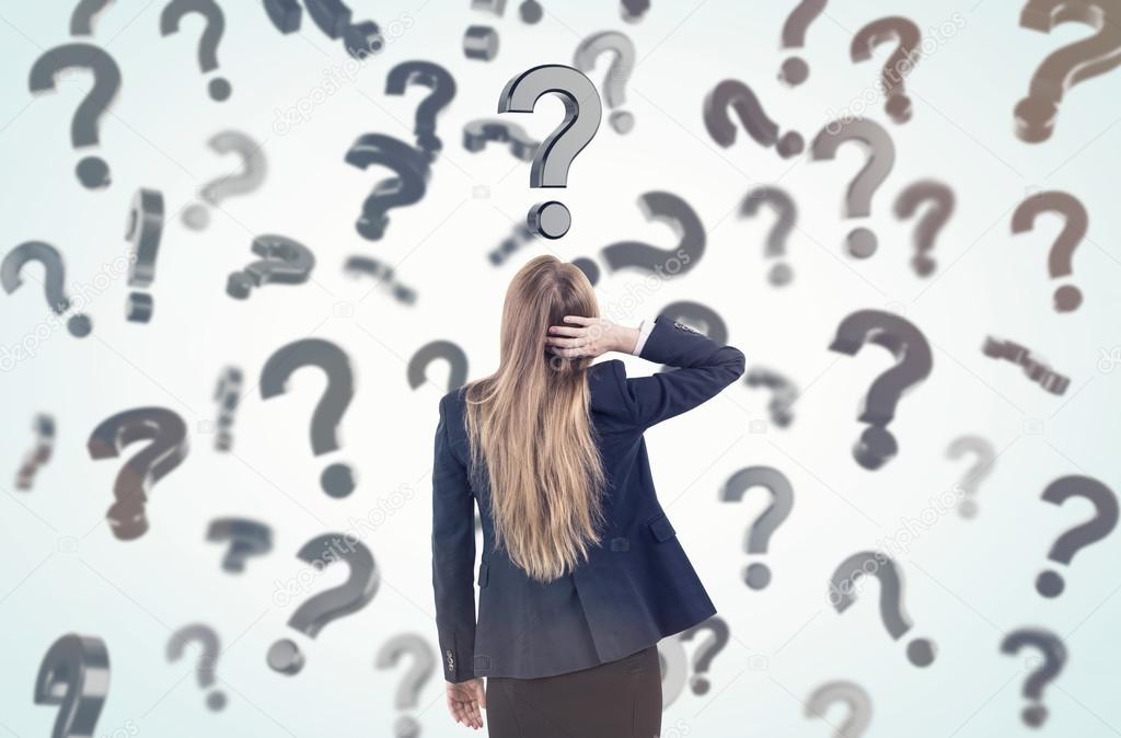Woman scratching head and looking at question marks