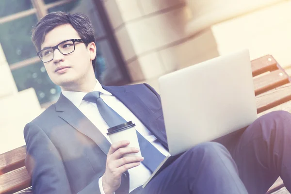 Empresario con café y portátil, tonificado — Foto de Stock