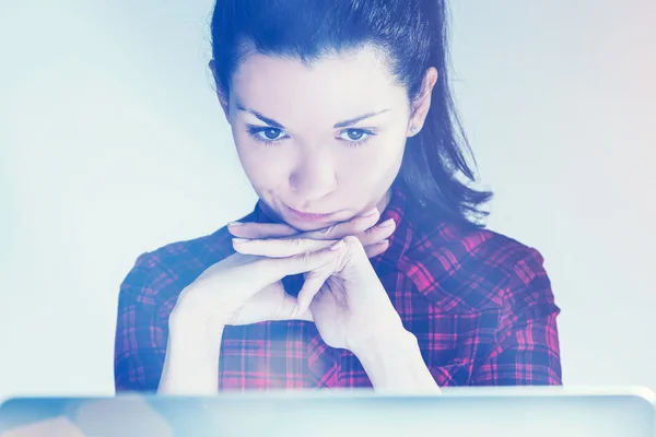 Ragazza pensante in camicia rossa e il computer portatile — Foto Stock