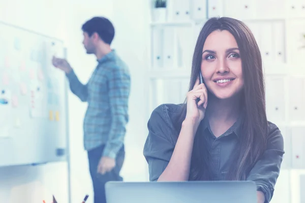 Kvinnan på telefonen och en man i office — Stockfoto