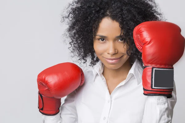 Улыбающаяся афроамериканка в красных боксёрских перчатках в воздухе — стоковое фото