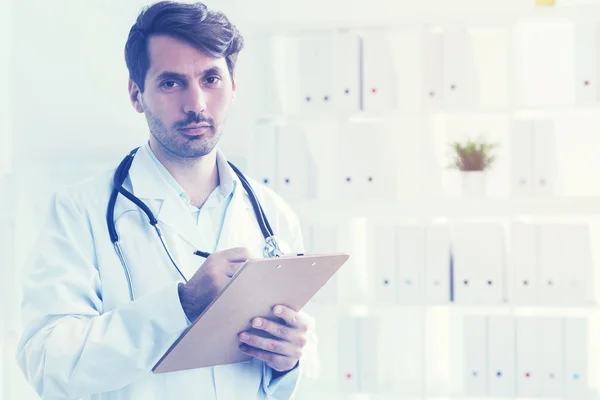 Médico sério com uma área de transferência — Fotografia de Stock