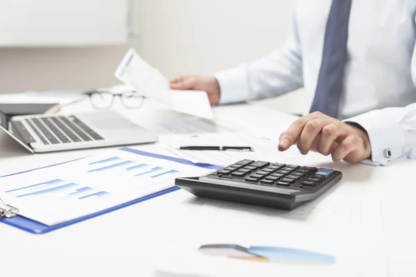 Man using calculator and holding important document — Stock Photo, Image