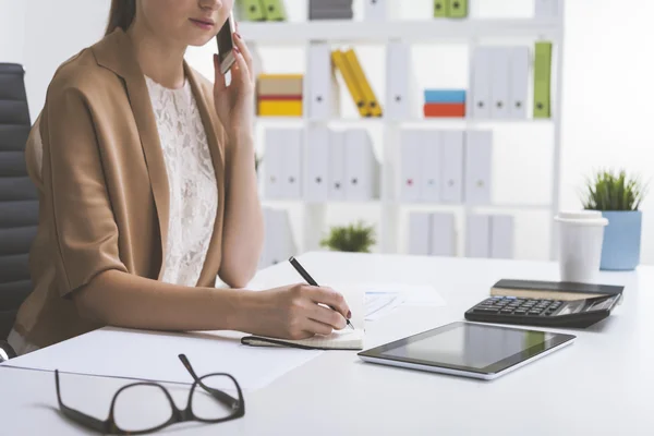 Ragazza in beige che parla sul cellulare e scrive — Foto Stock