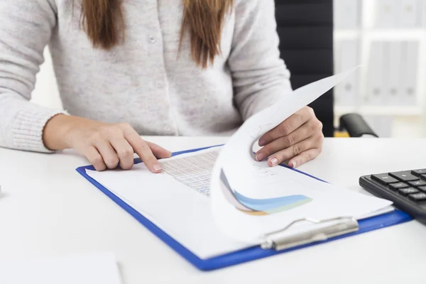 Woman in gray cardigan is reading a report — Stock Photo, Image