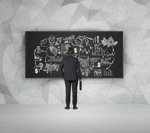 Businessman with suitcase is looking at blackboard with sketch — Stock Photo, Image