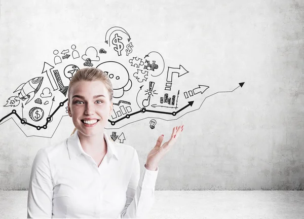 Blond woman showing startup sketches on concrete wall — Stock Photo, Image