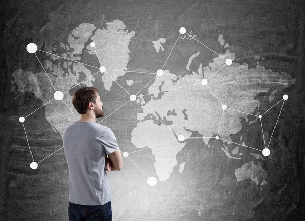 Hombre con camiseta está mirando el mapa del mundo —  Fotos de Stock