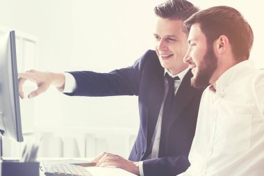 Bilgisayar ekranı işaret eden iki iş ortakları