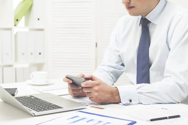 Man playing at his cell phone at work — Stock Photo, Image