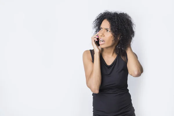 Enojada africana chica está hablando en su teléfono móvil —  Fotos de Stock