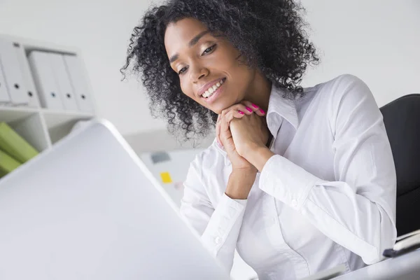 Vista lateral da mulher da África está olhando para a tela do laptop em de — Fotografia de Stock
