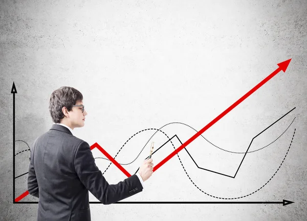 Man holding red marker is drawing red graph on concrete wall — Stock Photo, Image