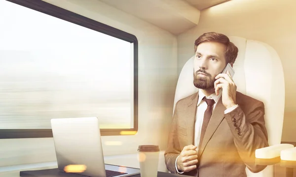 Empresario barbudo está hablando en su móvil en tren, tonificado — Foto de Stock
