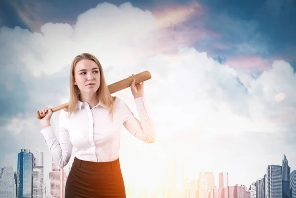 Businesswoman with baseball bat is standing in the city — Stock Photo, Image