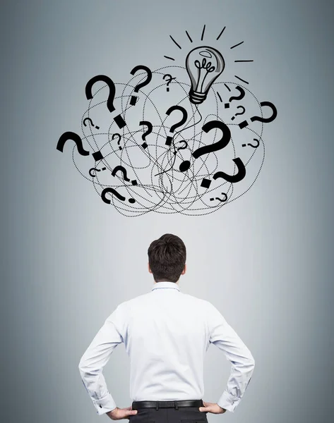 Rear view of man looking at question marks — Stock Photo, Image