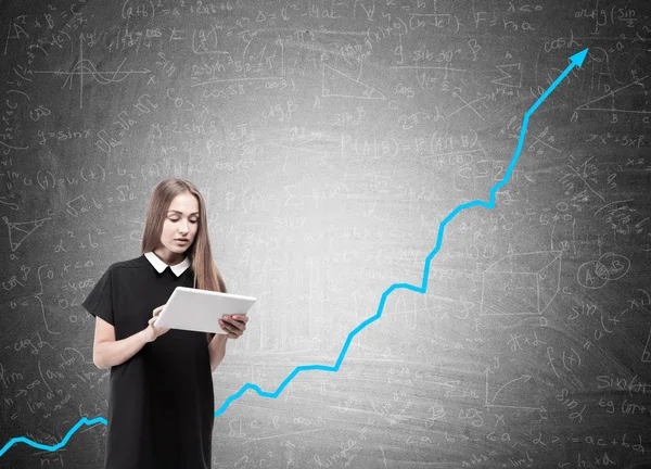 Woman with tablet and blue graph on blackboard — Stock Photo, Image