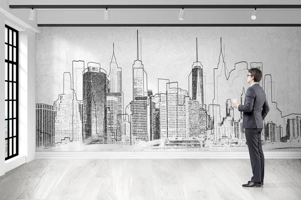 Businessman with coffee looking at city sketch — Stock Photo, Image