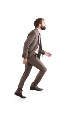 Side view of a businessman climbing an invisible ladder clipart