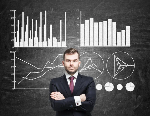 Seriös affärsman och fyra grafer på blackboard — Stockfoto