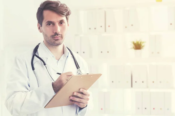 Médico sério com a sua prancheta — Fotografia de Stock