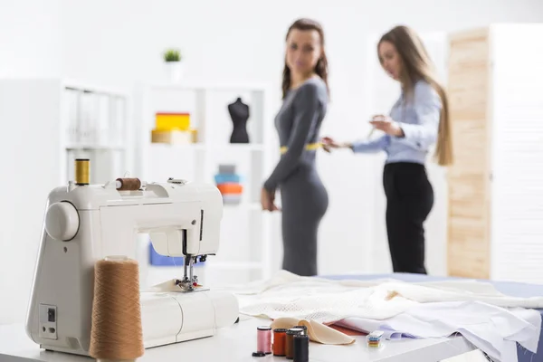 Mulher está medindo seu amigo para costurar roupas — Fotografia de Stock