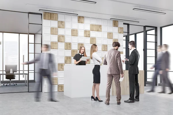 Люди работают в офисном холле с плиточным белым и деревянным покрытием — стоковое фото