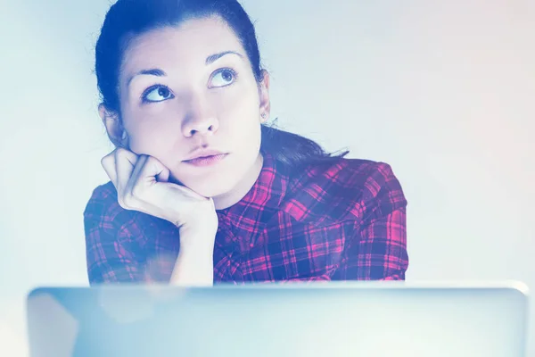 Fundersam tjej i röd skjorta och hennes laptop — Stockfoto