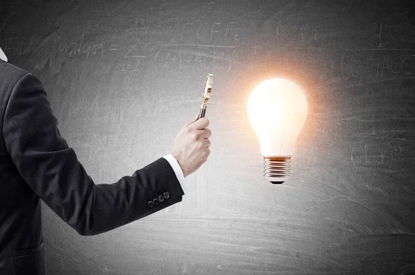 Man's hand with magnifying glass and a light bulb — Stock Photo, Image