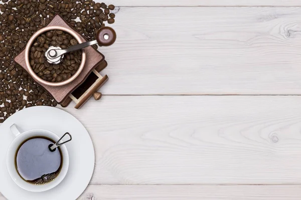 Vista superior de um moedor de café e uma xícara de pé nos grãos — Fotografia de Stock