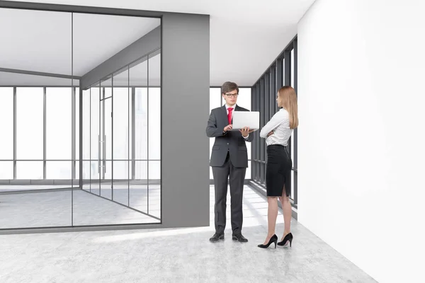 Pessoas em um escritório vazio com paredes de vidro e concreto branco — Fotografia de Stock