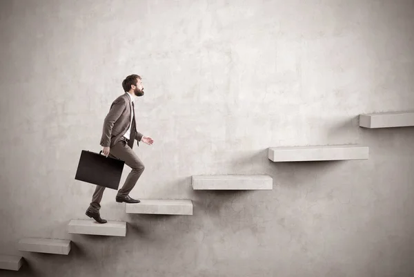 Вид сбоку бизнесмена, поднимающегося по бетонной лестнице — стоковое фото