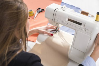 Kadının elinde bir dikiş makinesi kullanarak yakın çekim
