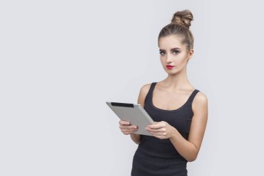 Siyah kolsuz bluz bir tablet ile bir topuz ile kız