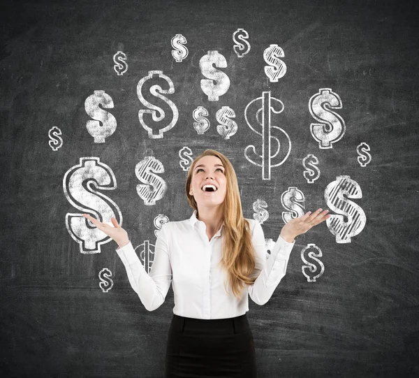 Cheerful blond businesswoman near blackboard with dollar signs — Stock Photo, Image