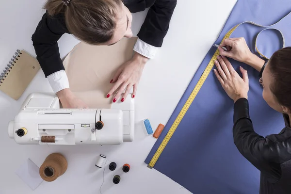 Two women sewing together in a tailor shop — Stock Photo, Image