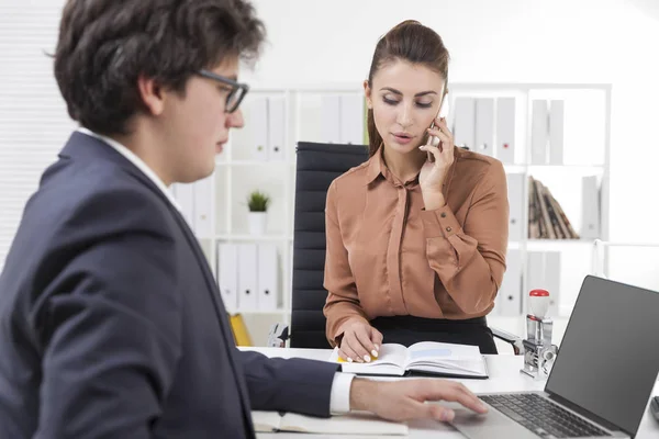 A mulher está ao telefone. Homem trabalhando no laptop — Fotografia de Stock