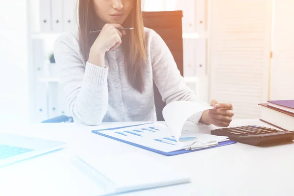 Zakenvrouw in witte kantoor is het bestuderen van een grafiek — Stockfoto