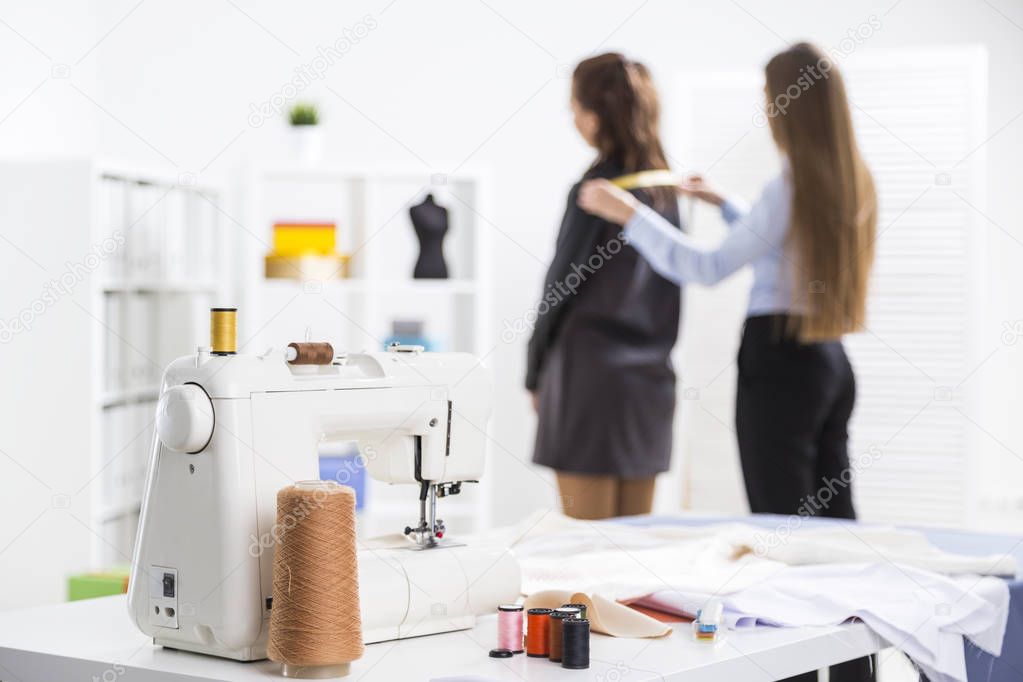 Woman is measuring her client at tailor shop