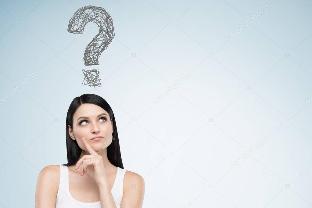 Woman in a tank top and question mark on blue wall