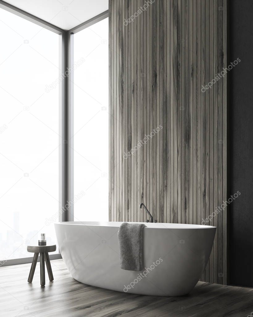 Corner of a bathroom with a tub and a wooden wall