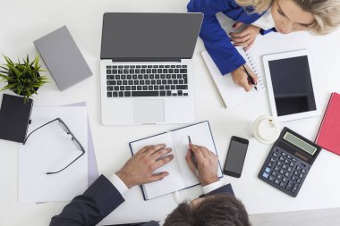 Adam yazıyor. Meslektaşı masanın üzerinden oturuyor