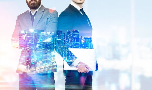 Two businessmen with crossed arms in office, skyscrapers and nig — Stock Photo, Image