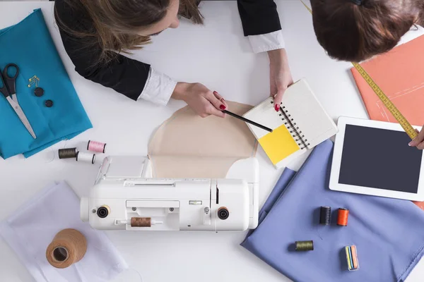 Mujer está mostrando su cuaderno a su colega con una medición — Foto de Stock