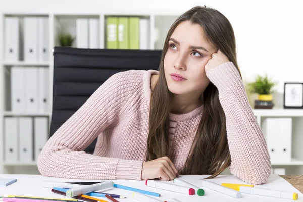 Bored woman painter in a pink sweater at her workplace — Stock Photo, Image