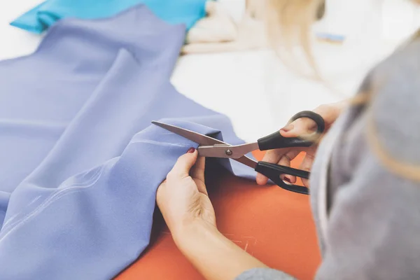 Close up de mulher cortando material azul — Fotografia de Stock