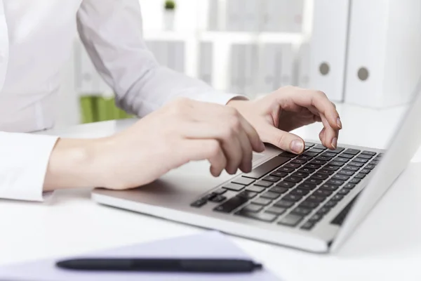 Side view of a woman with short nails typing — Stock Photo, Image