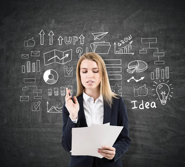 Vrouw met documenten in de buurt van een startup idee schets op een schoolbord — Stockfoto