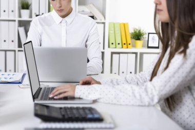 İki kadın arkadaşları onların kucak beyaz bir ofiste çalışan